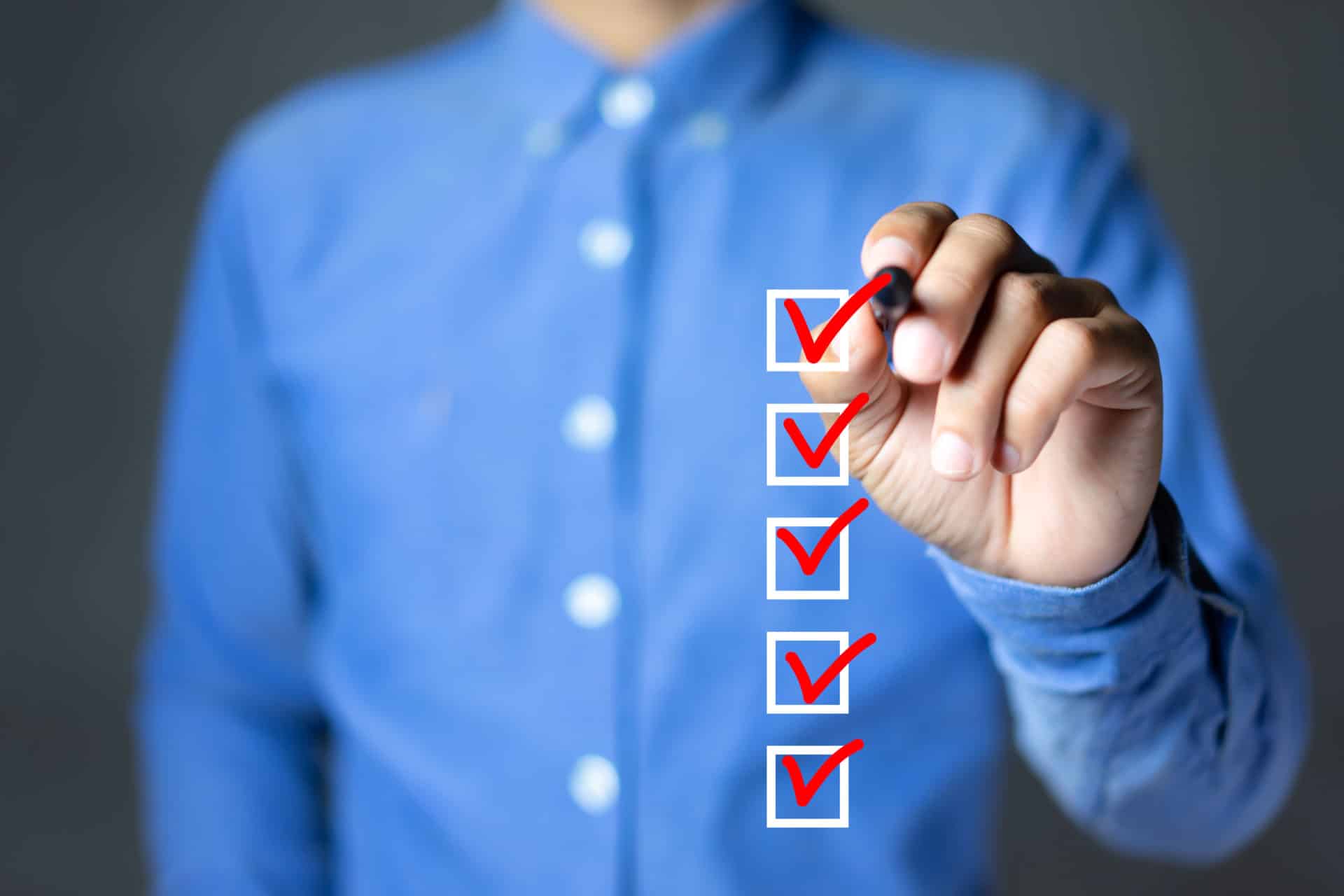 Checklist concept, Businessman checking mark on the check boxes with marker red Checklist
